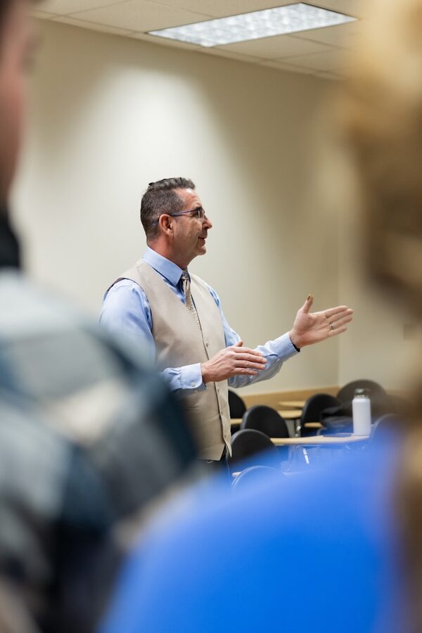 Troy Cox teaching a language testing class, gesturing mid-explanation to students